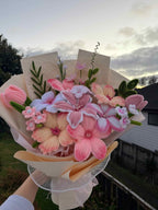 Close view of pink lilies and tulips in pastel wrapping